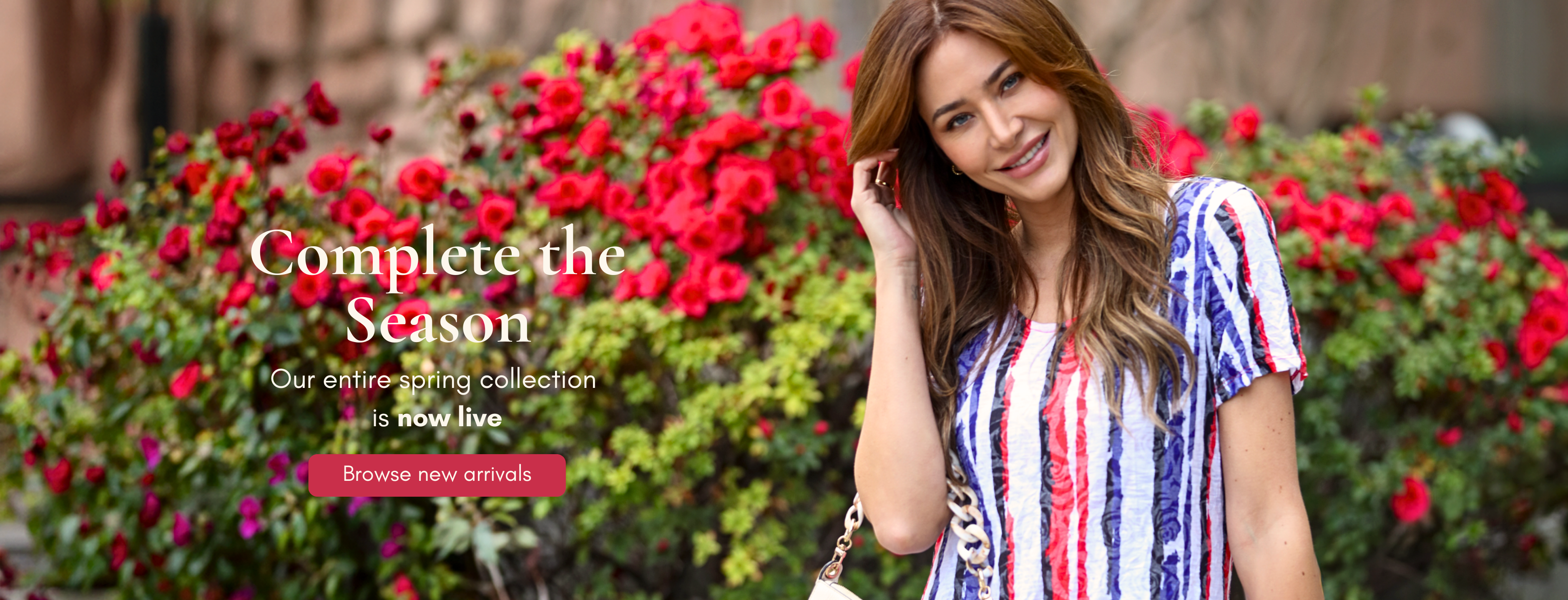 Woman in striped dress in front of red flowers with text ‘Complete the Season – Our entire spring collection is now live